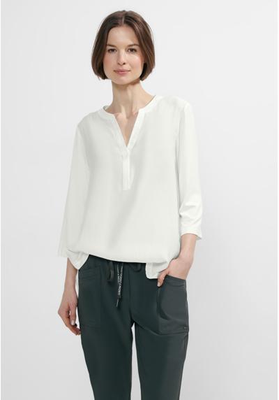 Блузка-рубашка с V-образным вырезом и удлиненной спинкой.