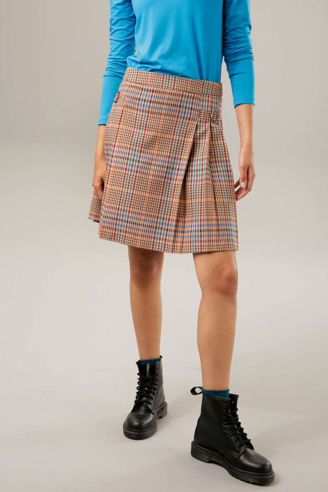 Плиссированная юбка с декоративными пряжками.