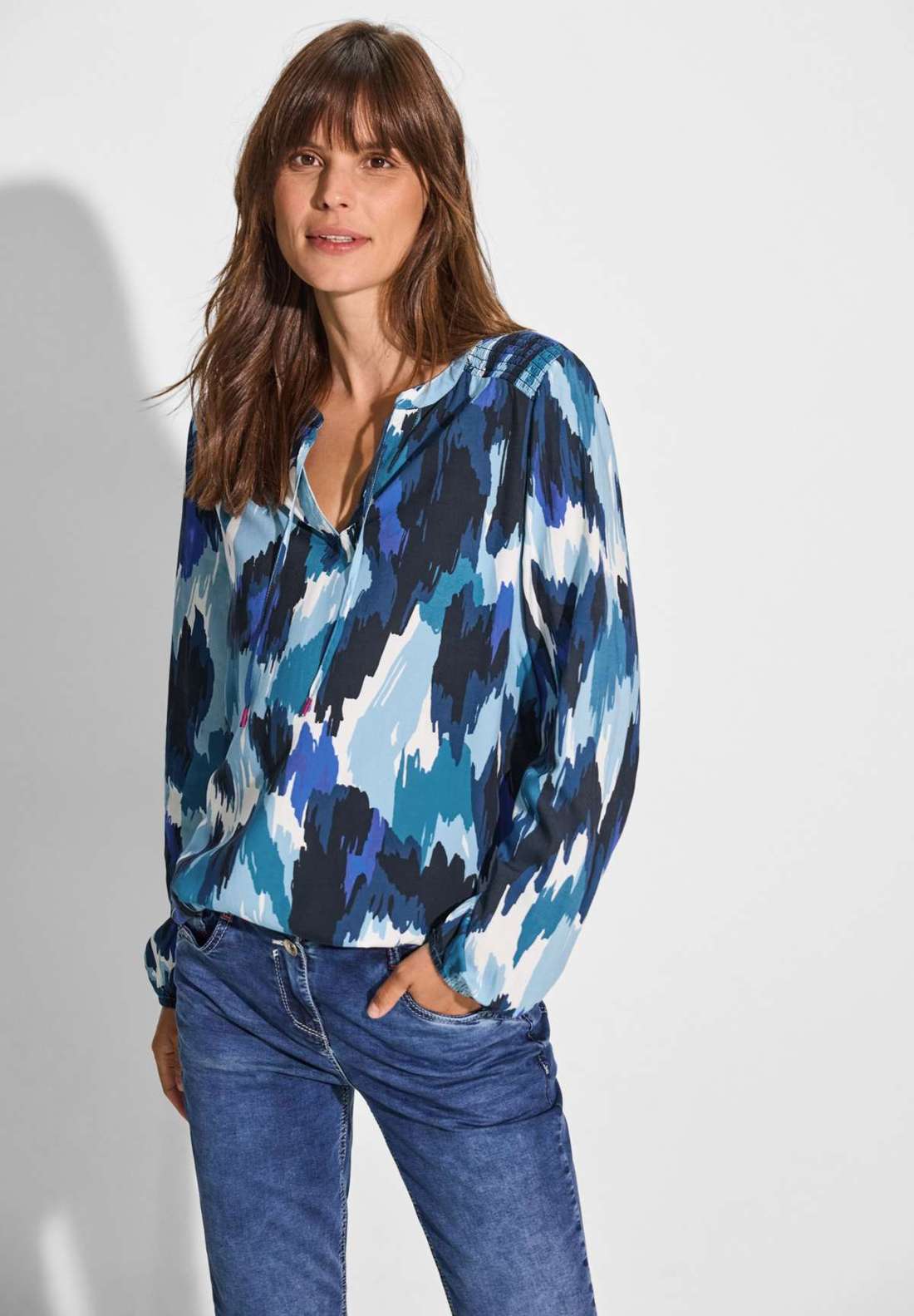 Блузка с длинными рукавами и вырезом под горло с лентами.