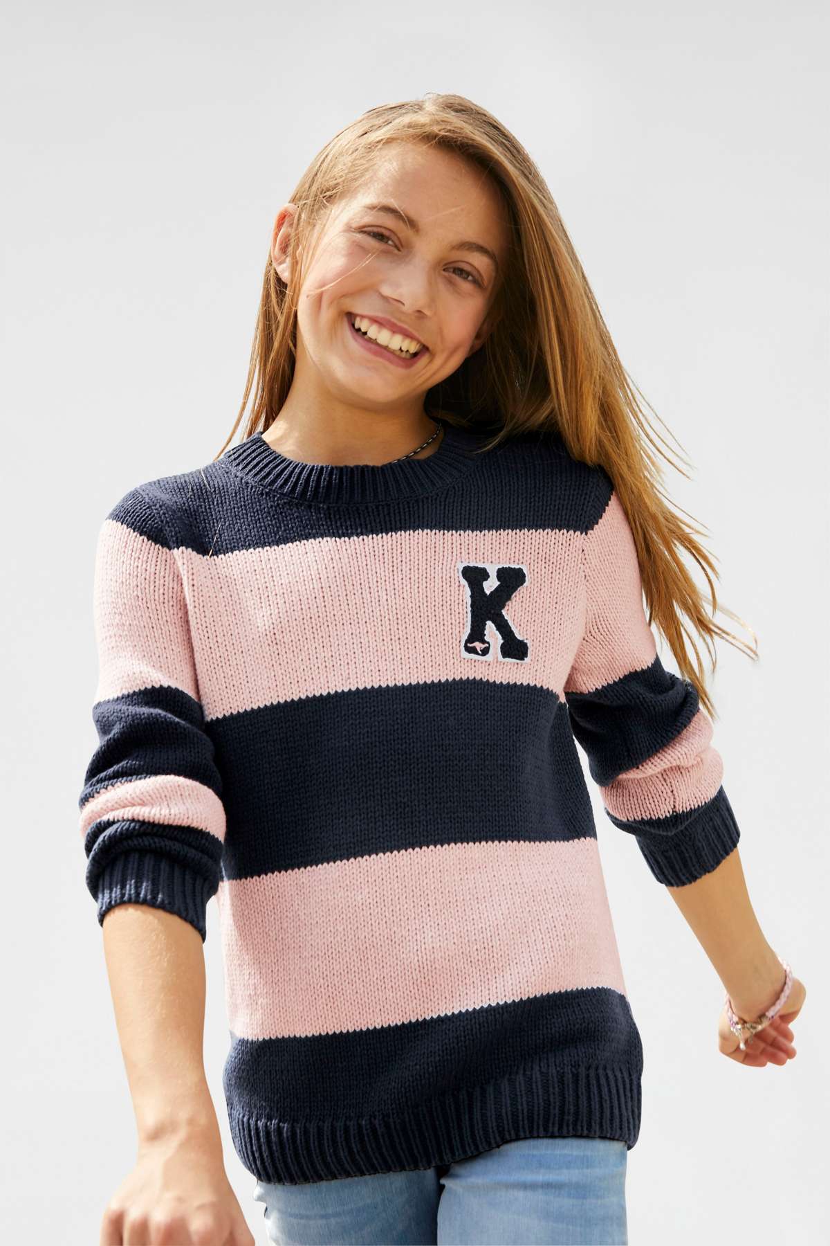 Вязаный свитер в модном образе в полоску.