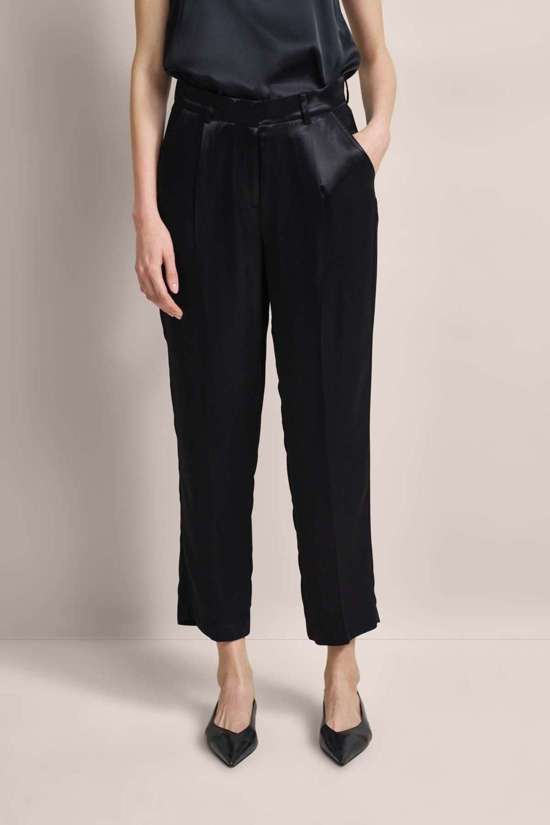 Брюки из ткани с запрессованными складками.