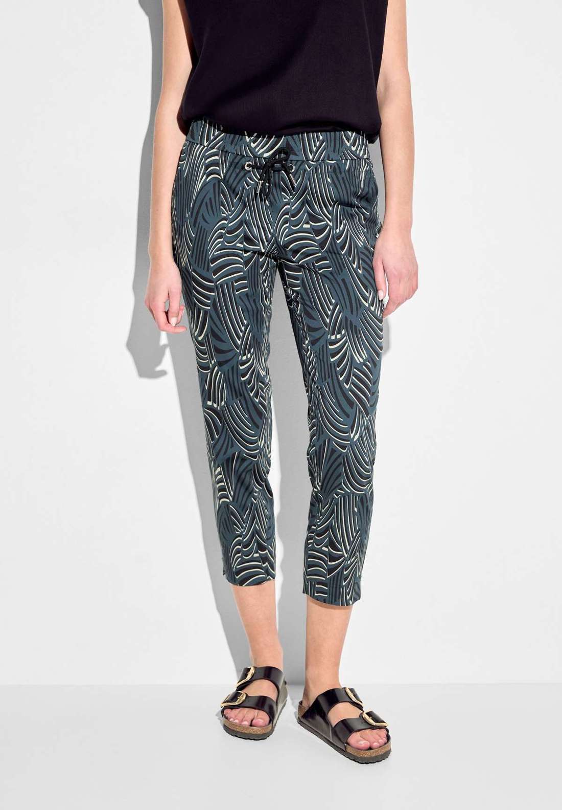 Узкие брюки с графическим принтом по всей поверхности.