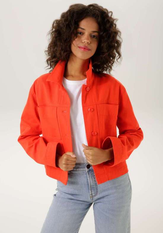 Джинсовая куртка застегивается на пуговицы в тон.