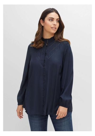 Блуза с длинными рукавами, присборенным вырезом и деталями из кружевного узора.