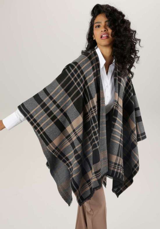 Вязаное пончо с клетчатым узором и бахромой.