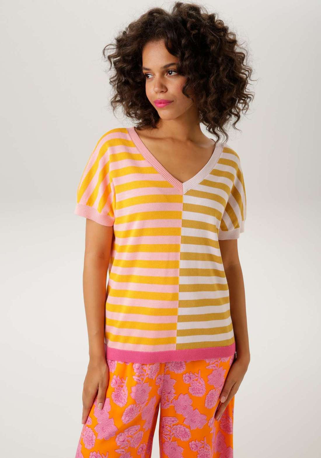 Вязаный свитер экстравагантного полосатого дизайна.