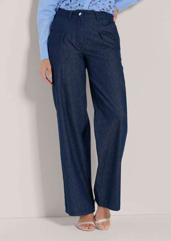 Широкие брюки с поясом и загнутыми складками.