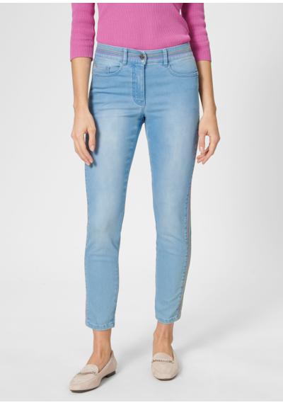 Узкие джинсы 7/8 с яркими полосатыми акцентами.