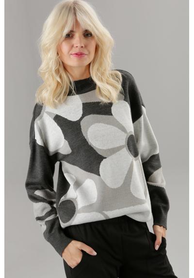 Вязаный свитер с крупным цветочным узором.